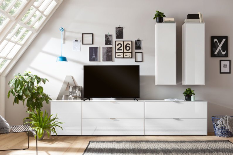 Minimalistische weiße Wohnwand mit breitem Lowboard und zwei schlanken Hängeschränken