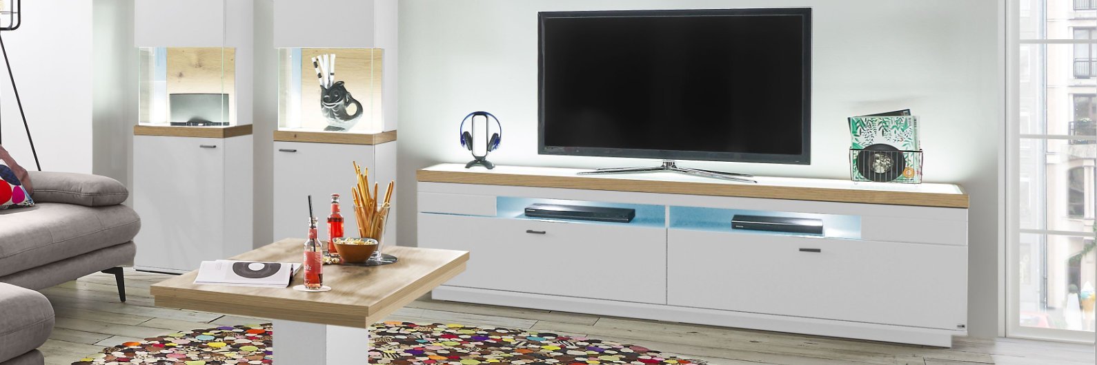 Weiße Wohnwand mit beleuchteten Vitrinen und Lowboard