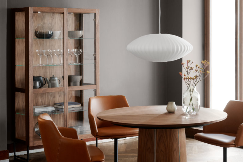 Esszimmer mit hochwertiger Vitrine, die Glasflächen mit hochwertigem Nussbaumholz kombiniert